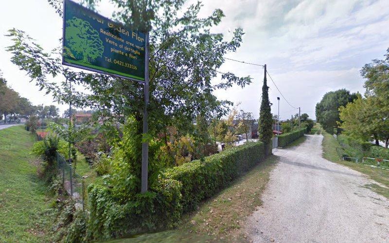 Un cartello all'ingresso di un viale alberato, con testo in francese, situato vicino a una stretta strada asfaltata e circondata dal verde.