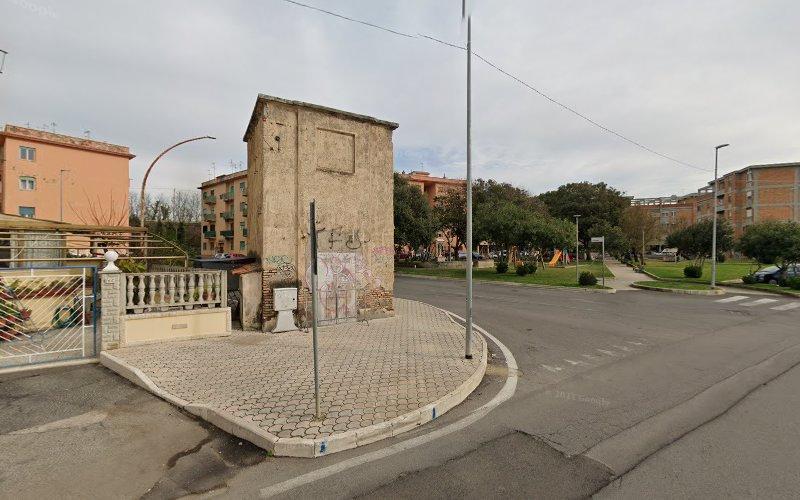 Un piccolo e antico edificio in pietra sorge all'angolo di una strada che interseca un parco.
