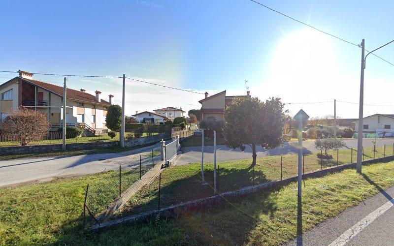 Un quartiere suburbano con case unifamiliari, una strada principale che interseca un viale, pali della luce e cieli sereni nelle giornate di sole.